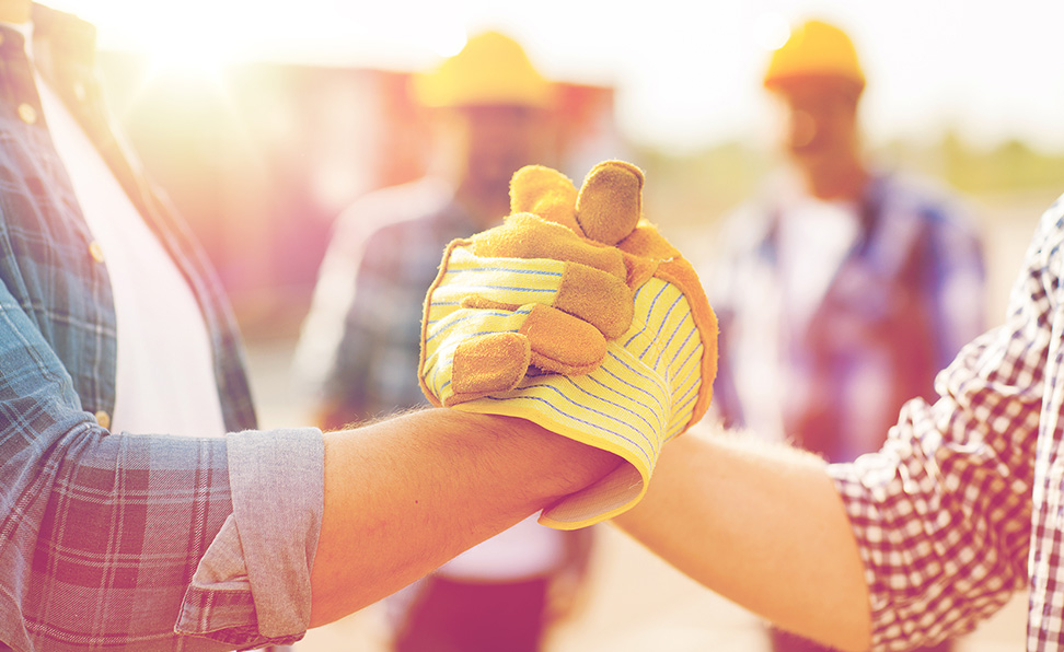 American workers shaking hands on a construction site